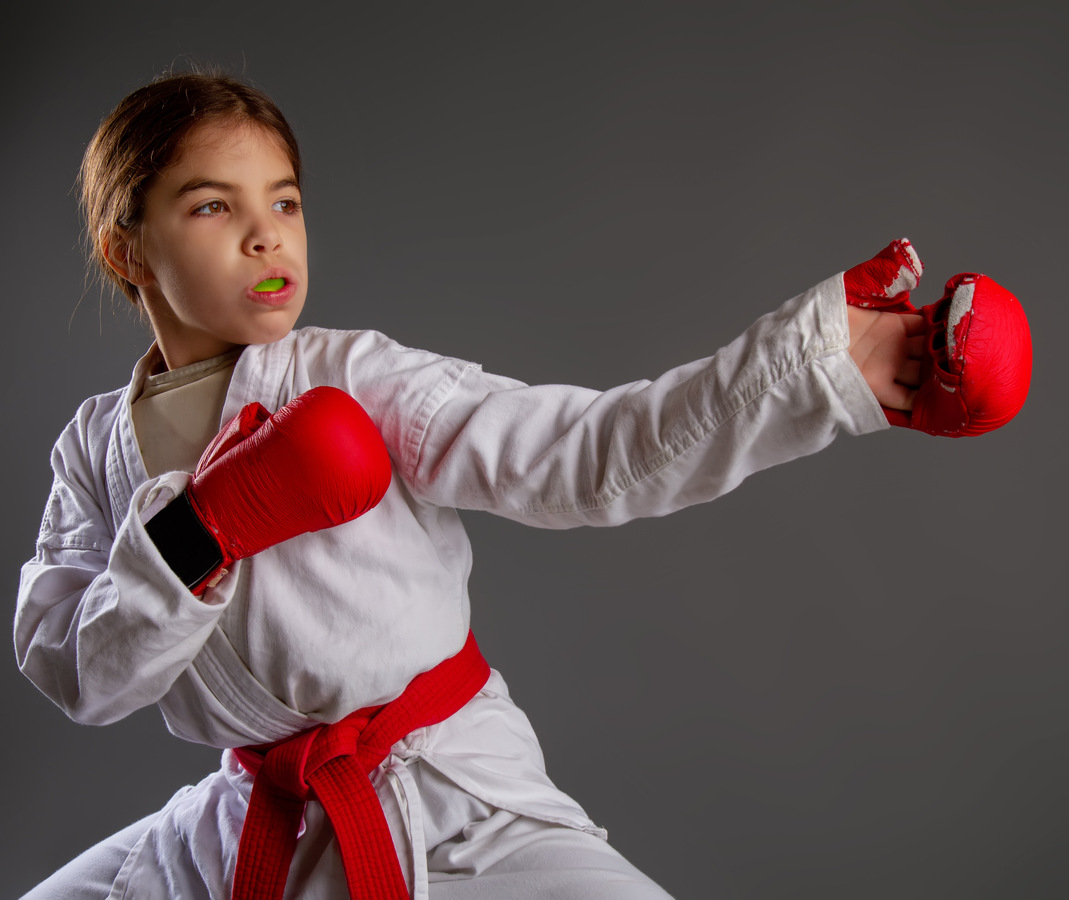 Child protecting their smile with a mouthguard while kickboxing